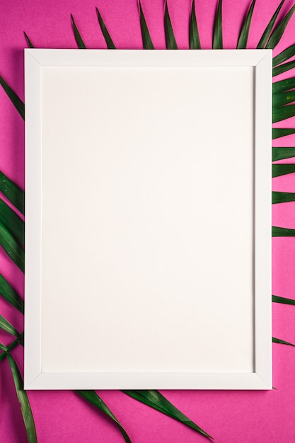 Marco blanco con plantilla vacía en hojas de palma, fondo rosa púrpura
