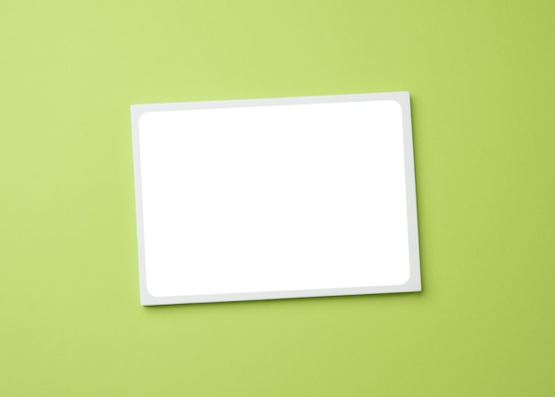 Foto marco blanco vacío sobre un fondo verde, espacio de copia