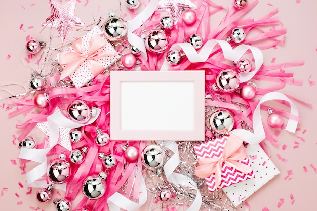 Marco con bolas de Navidad, regalos, cintas y adornos en color rosa con espacio para copiar texto. Fondo de vacaciones. Endecha plana, vista superior