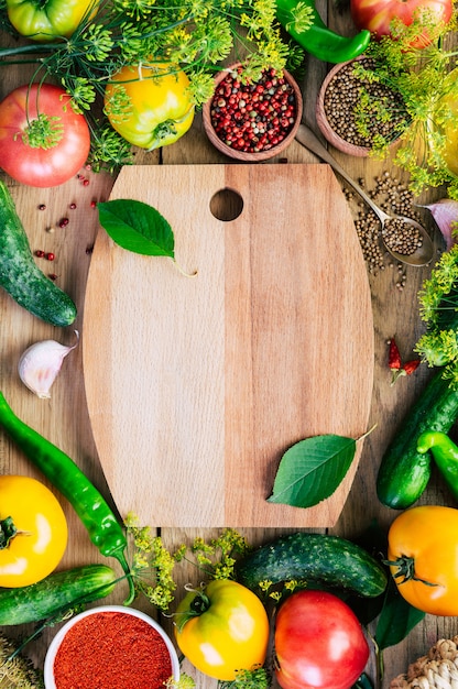 Marco de comida. Varias verduras, tabla de cortar de madera.