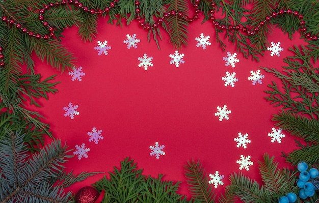 Marco de copos de nieve y ramas de árboles de Navidad