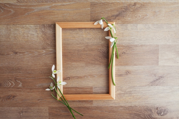 Marco decorado con flores de campanillas en la mesa rústica de madera, fondo de vacaciones para su decoración. Concepto de vacaciones de primavera y Pascua con espacio de copia.