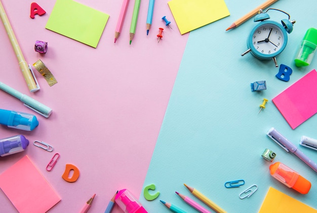 Marco de diferentes artículos de papelería en rosa y fondo, plano con espacio para texto. De vuelta a la escuela