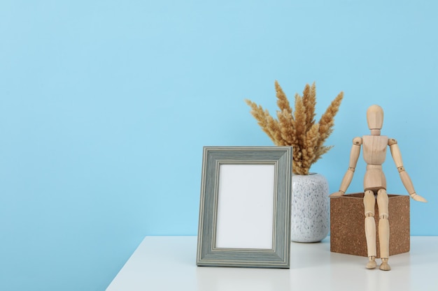 Un marco una estatuilla de un hombre y flores en una mesa