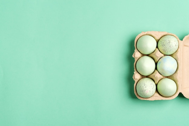 Foto marco festivo de pascua de caja de papel de huevos pintados de verde hecho a mano en color verde.
