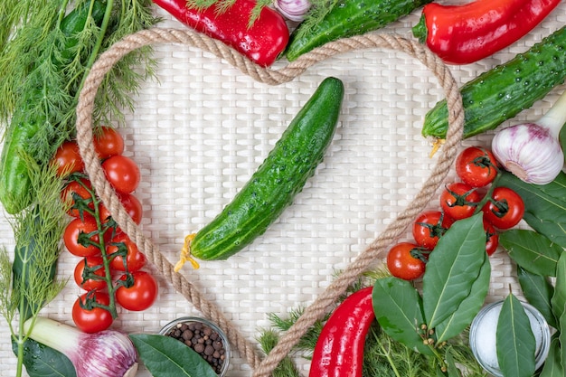 Un marco en forma de corazón con verduras y pimientos rojos.