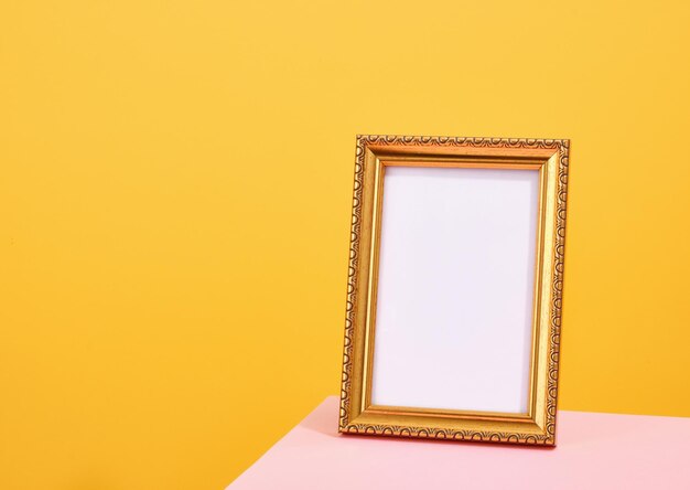 Un marco de fotos dorado se encuentra en la mesa Copiar espacio para el texto