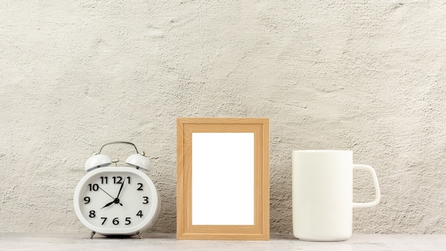 Marco de fotos de madera clásico con un reloj y una taza de café blanco.