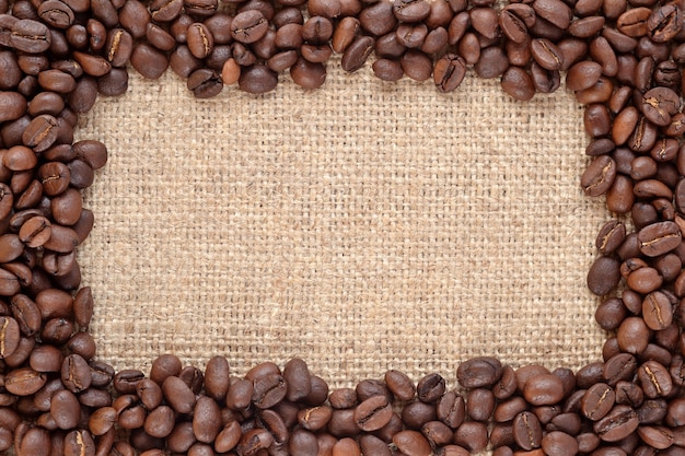 Marco de granos de café marrón y bien tostados naturales en un fondo de despido