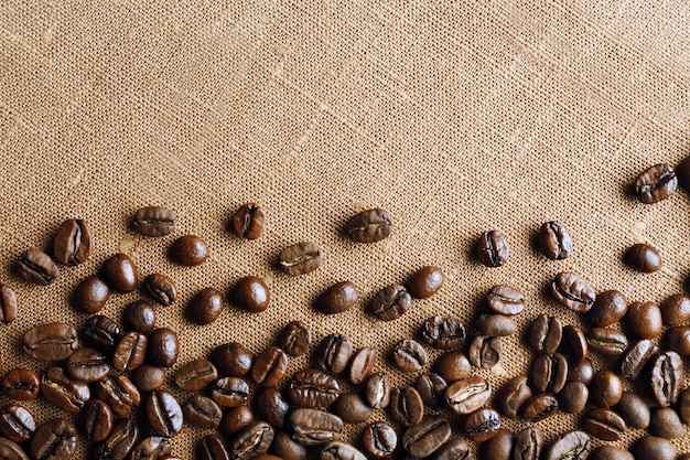 Marco de granos de café sobre fondo de tela de saco de color