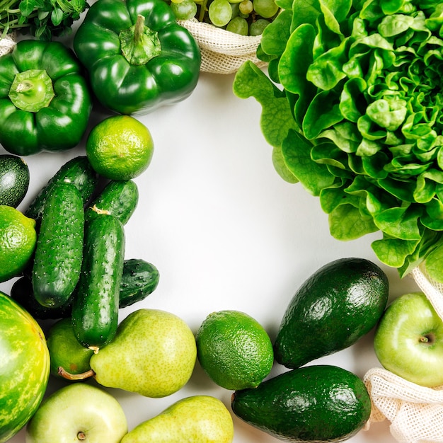 Marco hecho de verduras orgánicas y verduras frescas sobre fondo blanco sobre fondo blanco.