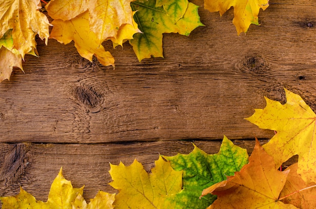 Marco de hojas caídas de otoño sobre fondo de madera rústica. Vista superior, .