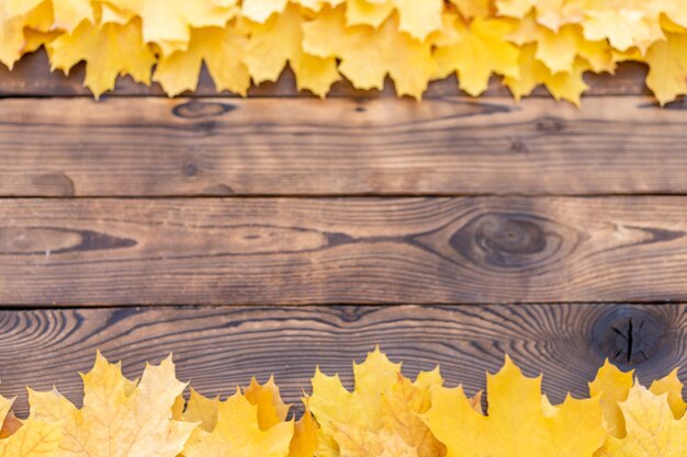 Marco de hojas de otoño en la vista superior de fondo de madera
