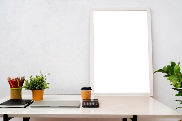 Marco de imagen en blanco en la mesa de madera con libros