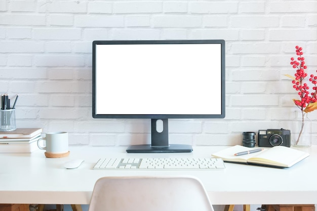 Marco de imagen de pantalla de computadora de escritorio en blanco de vista frontal y portalápices en mesa blanca