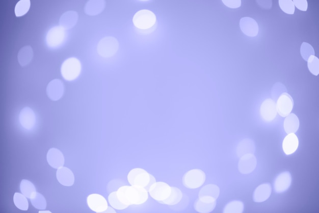 Marco de luces de Navidad borrosas en color de moda del año 2022 Very Peri. Guirnalda de Navidad abstracta borrosa. Desenfoque bokeh, fondo desenfocado. Bokeh festivo. Copie el espacio para el texto. Orientación horizontal.