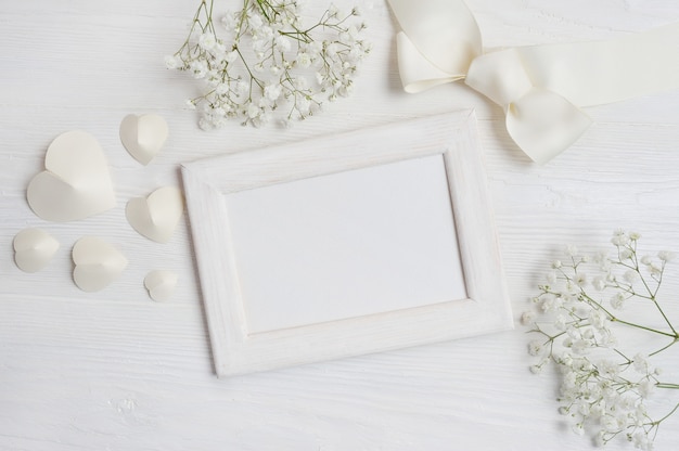 marco de madera blanca con corazones y flores y tarjeta de lazo para San Valentín