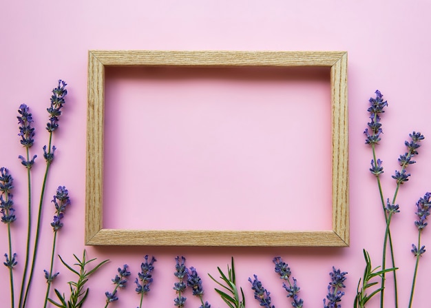 Marco de madera con hermosas flores de lavanda fragante sobre fondo rosa