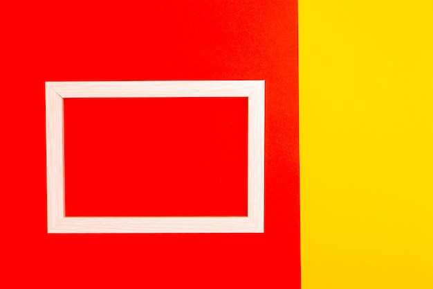 Foto marco de madera sobre un fondo rojo-amarillo. vista desde arriba