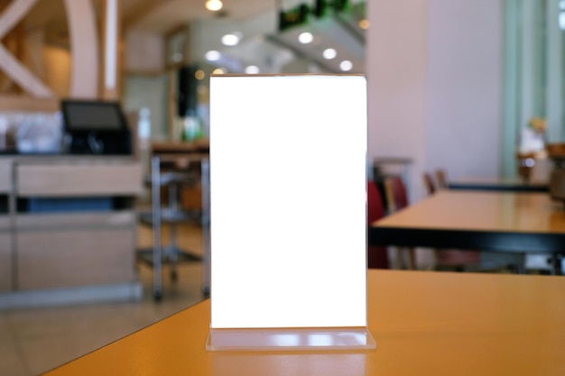 Marco de menú de pie sobre una mesa de madera en el espacio de la cafetería del restaurante Bar para la promoción de marketing de texto