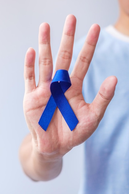 Março Mês de conscientização do câncer colorretal Mulher segurando fita azul escura para apoiar pessoas que vivem e doenças Esperança de saúde e conceito do dia mundial do câncer