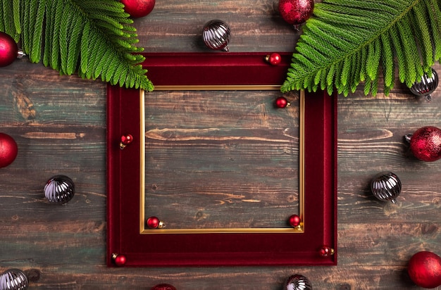 Marco de Navidad rojo con hoja de pino y decoración de adorno en mesa de madera