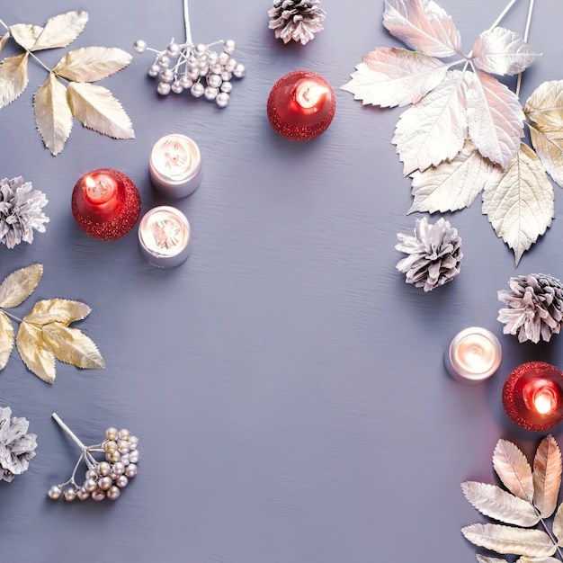 Marco navideño con hojas de plata y velas.