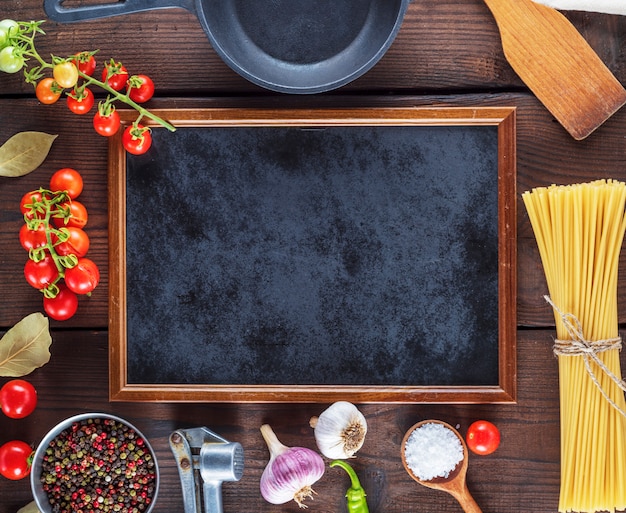 Marco negro vacío e ingredientes para cocinar pasta.