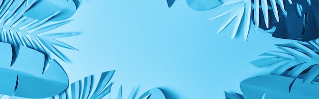 marco de papel minimalista azul cortado hojas de palma en fondo azul con espacio de copia