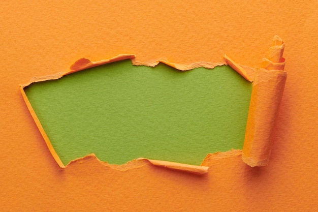 Marco de papel rasgado con bordes rasgados Ventana para texto con espacio de copia colores naranja verde fragmentos de páginas de cuaderno fondo abstracto