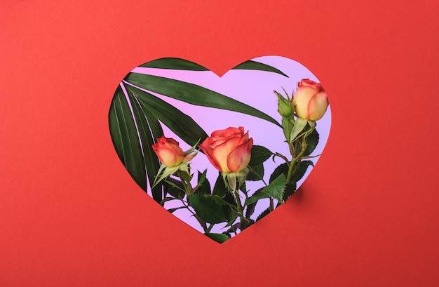 Marco de papel rojo en forma de corazón con rosas y rama de palma