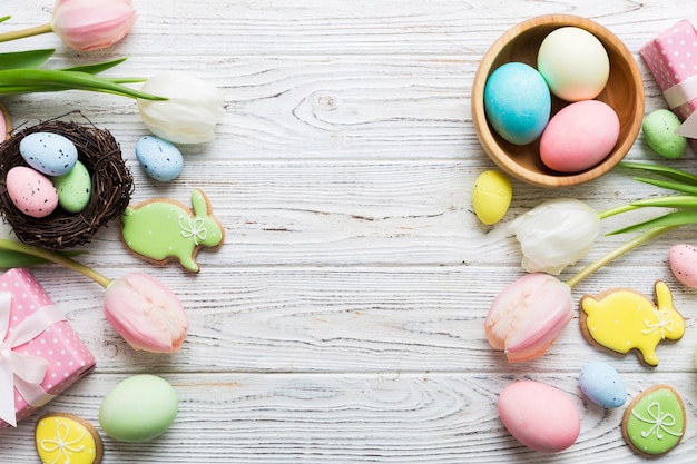 Marco de Pascua con caja de regalos de huevos y tulipán en un fondo coloreado El concepto minimalista Vista superior Composición de feliz Pascua Tarjeta con un espacio de copia del lugar para el texto