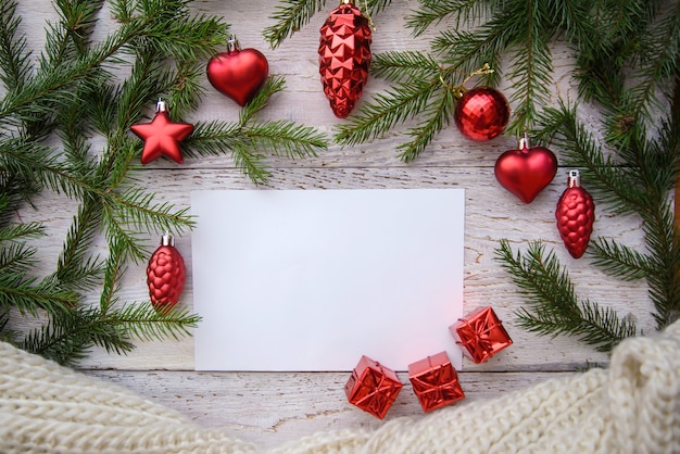 Marco de ramas de árboles de Navidad y juguetes rojos sobre un fondo de madera