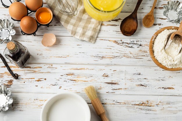 Marco de repostería, ingredientes, utensilios de cocina en madera rústica