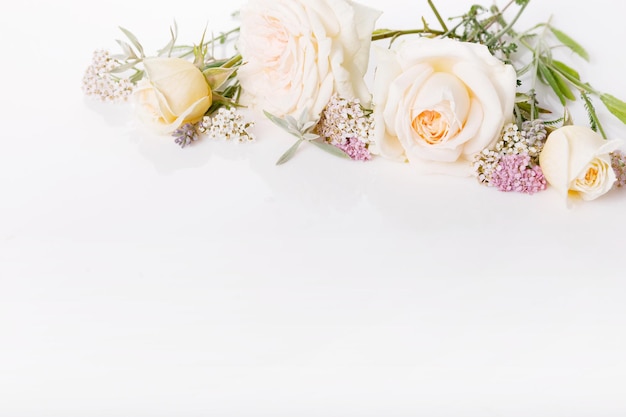 Marco de rosas delicadas ligeras sobre un fondo blanco