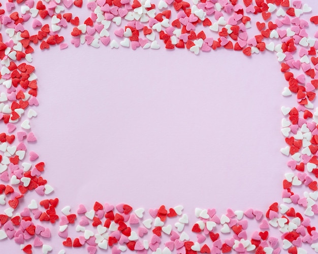 Foto marco de san valentín hecho de corazones de azúcar rojo, blanco y rosa