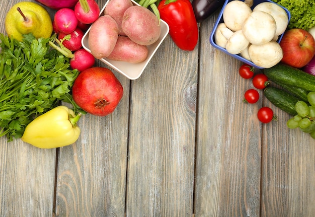 Marco de verano con frutas y verduras orgánicas frescas sobre fondo de madera