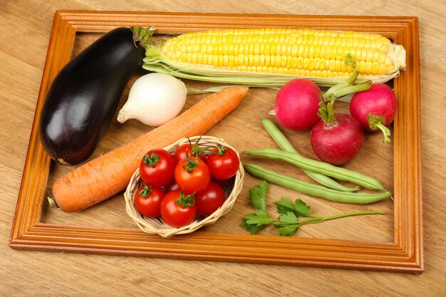 Marco de verano con frutas y verduras orgánicas frescas sobre fondo de madera