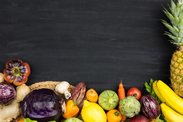 Foto marco de verduras frescas y frutas en el fondo de chalk negro.