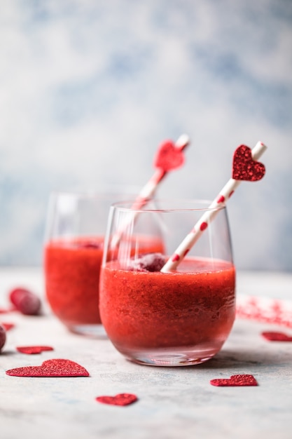Margarita de fresa roja fresca o cóctel daiquiri con corazones sobre fondo gris, conceptos del día de San Valentín