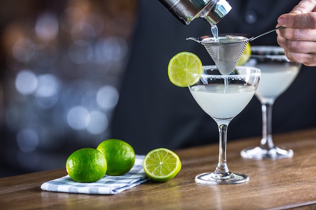 Margarita. Margatita alkoholisches Cocktailgetränk auf der Bartheke im Pub oder Restaurant. Barkeeper bereitet einen Cocktail zu.