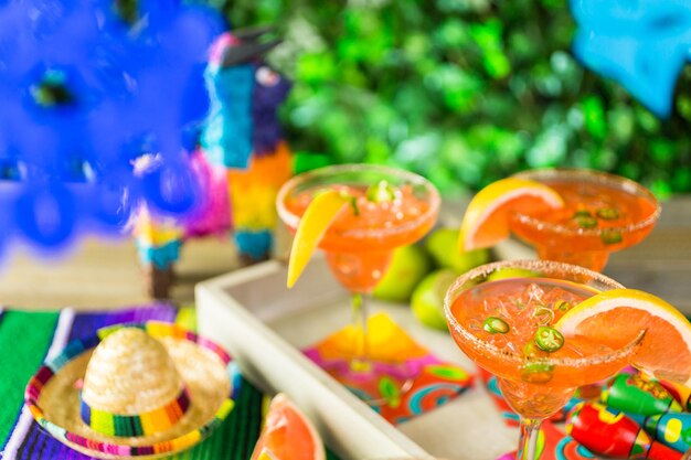 Foto margarita picante de pomelo con hielo en vasos de margarita sobre la mesa en el jardín.