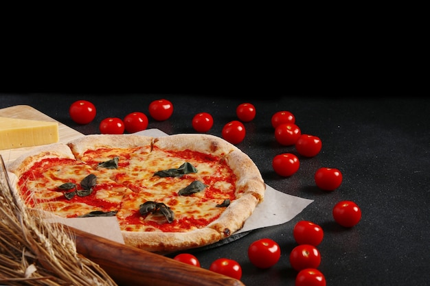 Margarita Pizza und Tomatenkirschen auf dunklem Hintergrund