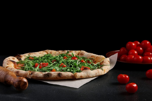 Foto margarita pizza und tomatenkirschen auf dunklem hintergrund