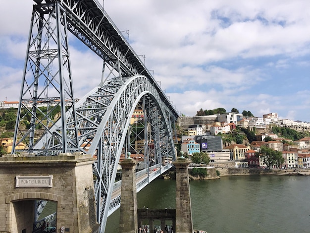 Maria Pia-Brücke über den Fluss von Gebäuden gegen den bewölkten Himmel