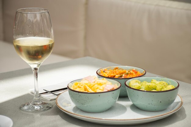 Maridaje con diferentes platos de pasta y una copa de vino blanco.