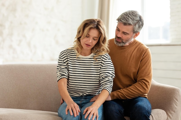 Marido abraçando esposa doente enquanto ela se sente mal em casa