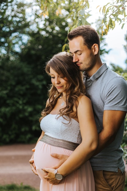 Foto marido abraçando esposa grávida ao ar livre