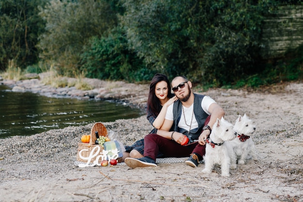 Marido com uma linda esposa passeando com seus cães brancos no parque