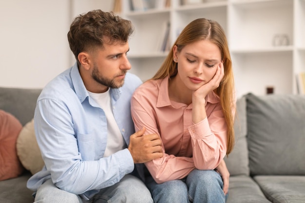 El marido compasivo abrazando y apoyando a la esposa molesta en el interior